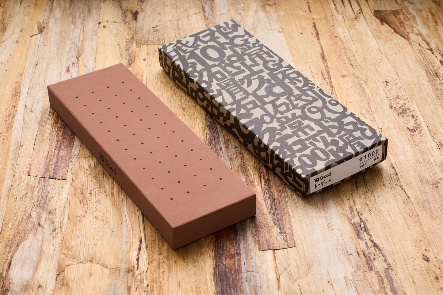 10 Good Medium 1000 Grit Stone with dotted surface, next to its packaging, ideal for beginners seeking reliable sharpening from Knifewear's curated Japanese collection.