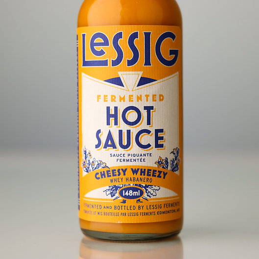 Cheesy Wheezy whey-habanero hot sauce, 148 mL bottle by Lessig Ferments, showcased for culinary enthusiasts seeking unique flavors to complement their Japanese kitchen tools.