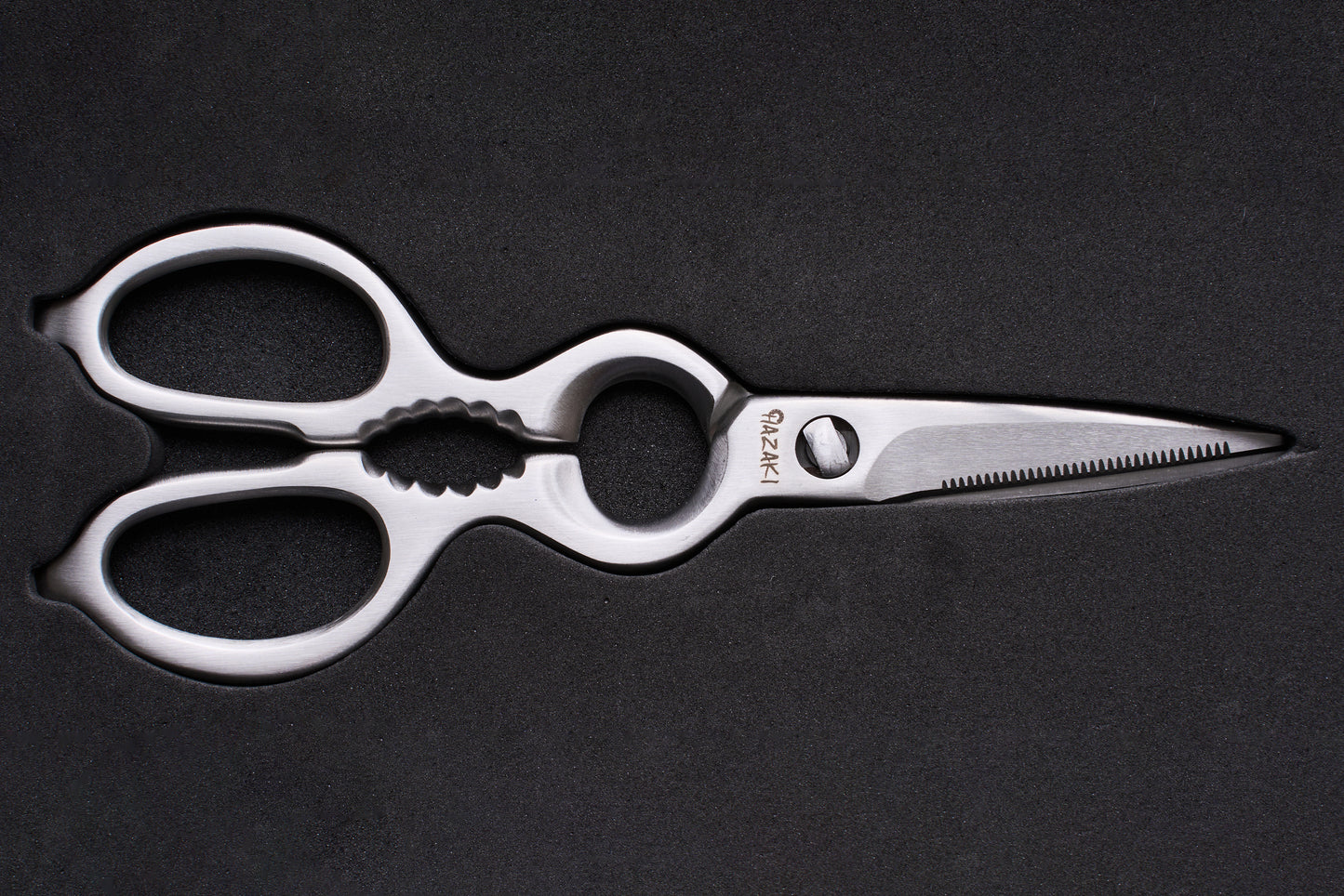 Hazaki Stainless Kitchen Shears, featuring polished stainless steel with ergonomic looped handles, a serrated blade, built-in nutcracker, and bottle opener, ideal for versatile kitchen use.