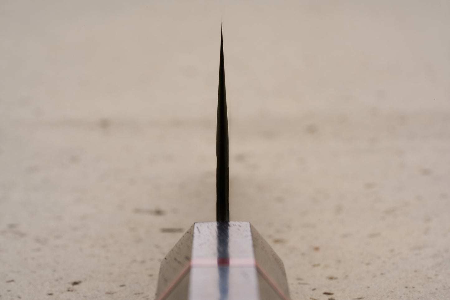 ICHIE x Shibata Knives SG2 Tsuchime Santoku 165mm, a sleek black blade rising sharply from a rectangular block with a red stripe, designed for slicing, dicing, and mincing in Western kitchens.