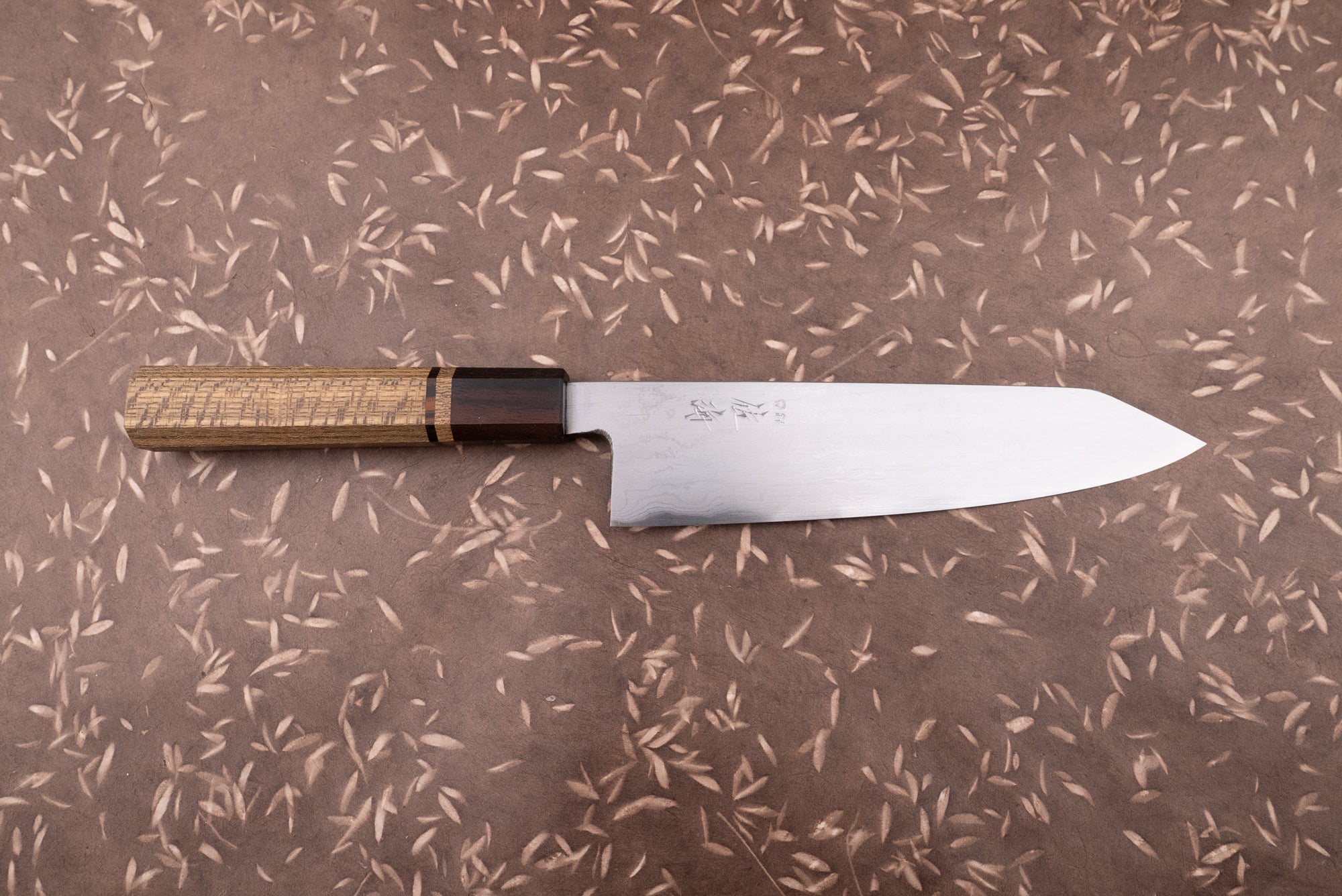 Touroku Sakai Aogami Damascus Kiritsuke Gyuto 210mm, featuring a stainless-steel blade with engraved kanji and an octagonal wooden handle, embodies masterful Japanese craftsmanship, ideal for culinary enthusiasts and professionals alike.