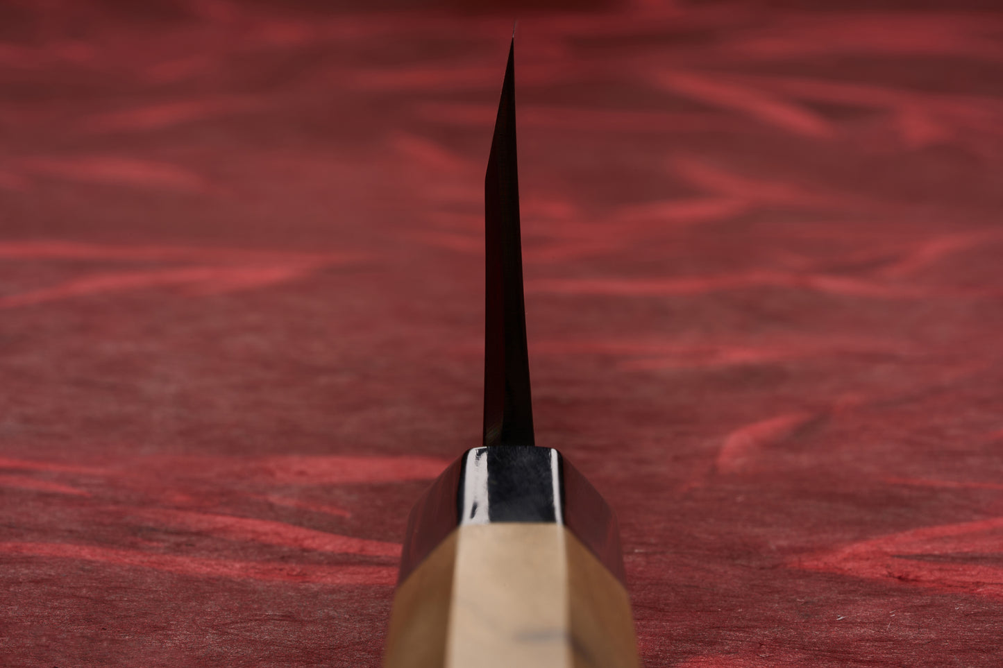 Touroku Sakai Tohwa Shirogami Deba 150mm knife, featuring a single bevel blade viewed head-on, with an octagonal wooden handle and black ferrule, set against a textured background.