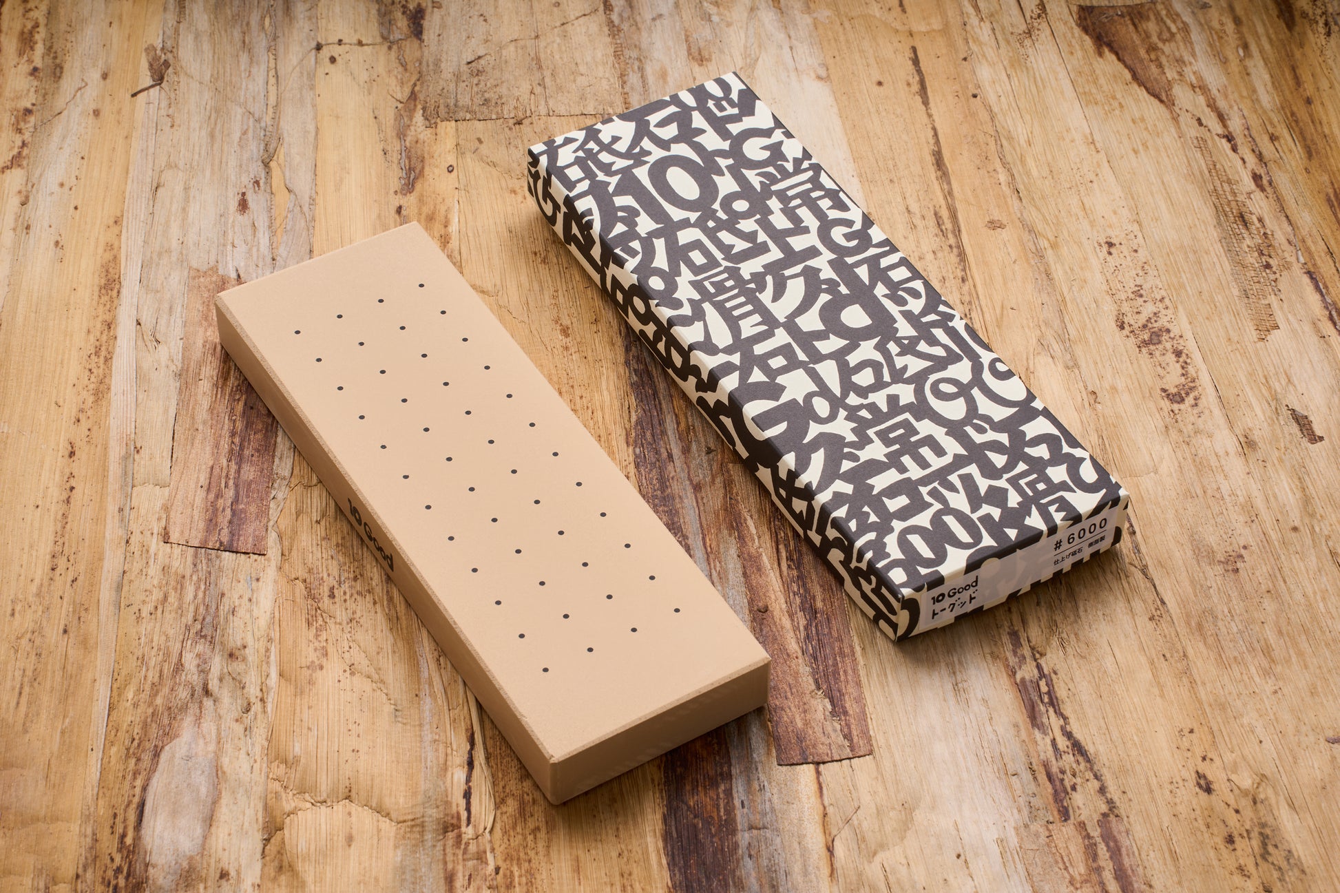 10 Good Fine 6000 Grit Stone on wood, unpacked with dotted surface for grip, alongside its box labeled “#6000” featuring stylized and Japanese characters.