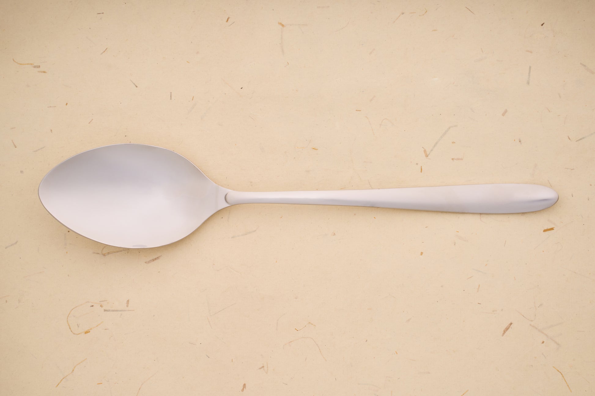 Arcos Berlin Series Serving Spoon, crafted from stainless steel, showcased on a textured background, reflecting the brand's rich legacy in quality blade craftsmanship since 1745.