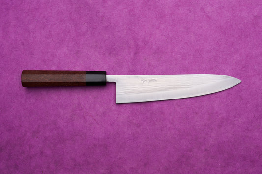 Fujimoto AS Sazanami Gyuto 210mm with a stainless-steel blade and octagonal wooden handle, displayed on a textured purple background.