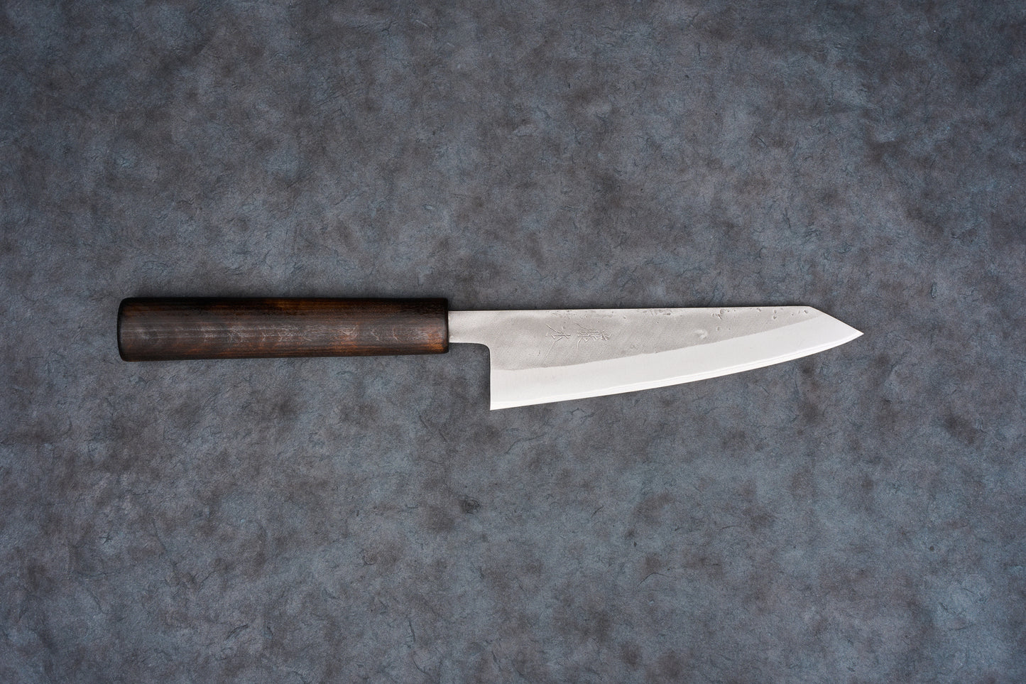 Fujimoto Nashiji Honesuki 150mm knife with a dark wooden handle and a long, narrow blade featuring a subtle textured finish, designed for precision in poultry and fish preparation.