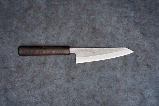 Fujimoto Nashiji Honesuki 150mm knife with a dark wooden handle and a long, narrow blade featuring a subtle textured finish, designed for precision in poultry and fish preparation.