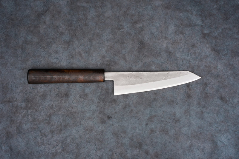 Fujimoto Nashiji Honesuki 150mm knife with a dark wooden handle and a long, narrow blade featuring a subtle textured finish, designed for precision in poultry and fish preparation.