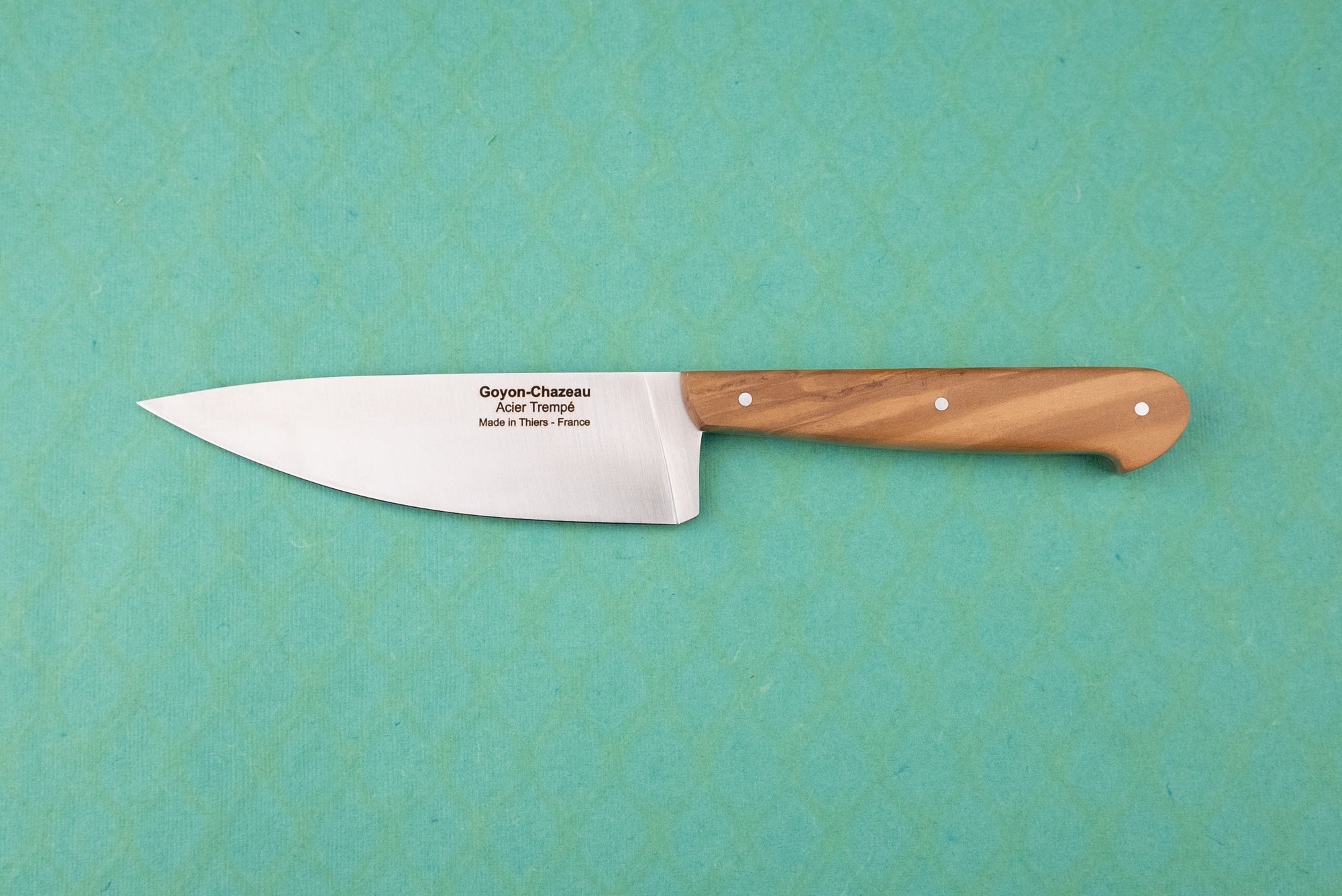 Goyon-Chazeau Le Grand Tradi chef's knife, featuring a long stainless-steel blade with engraved details, and a smooth, riveted wooden handle, designed for precision in smaller kitchen tasks.