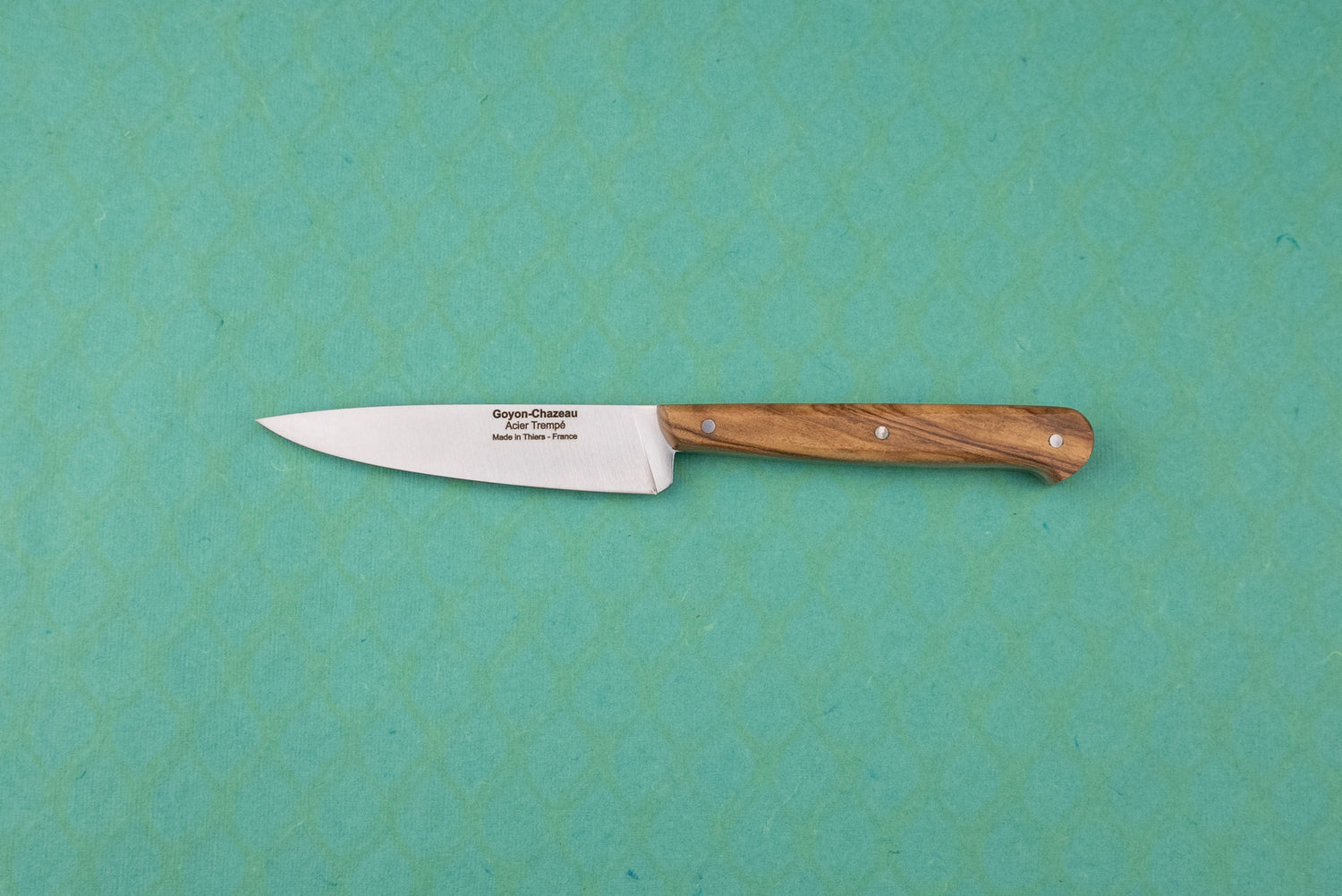 Goyon-Chazeau Le P'tit Tradi: A slim utility paring knife with a wooden handle and stamped stainless steel blade, ideal for precise kitchen tasks like slicing shallots and herbs.