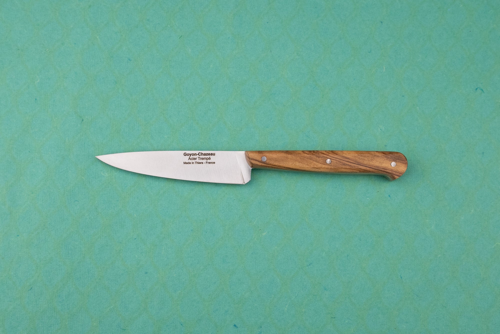 Goyon-Chazeau Le P'tit Tradi: A slim utility paring knife with a wooden handle and stamped stainless steel blade, ideal for precise kitchen tasks like slicing shallots and herbs.