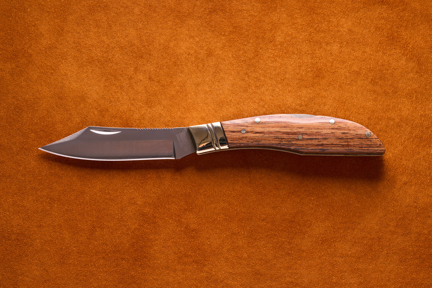 Grohmann Mini Russell Lockblade with Rosewood Handle, featuring a 4 stainless steel clip point blade, displayed open on a suede surface.
