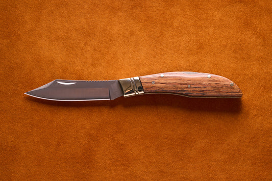 Grohmann Mini Russell Lockblade with Rosewood Handle, featuring a 4 stainless steel clip point blade, displayed open on a suede surface.
