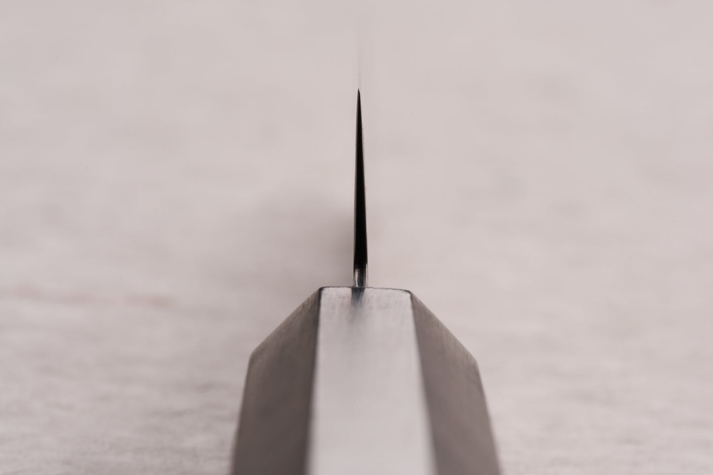 Close-up of the Hatsukokoro Ryuhyo SG2 Kurozome Damascus Petty 150mm knife's blade, showcasing its sharp edge and precision craftsmanship, ideal for delicate kitchen tasks.