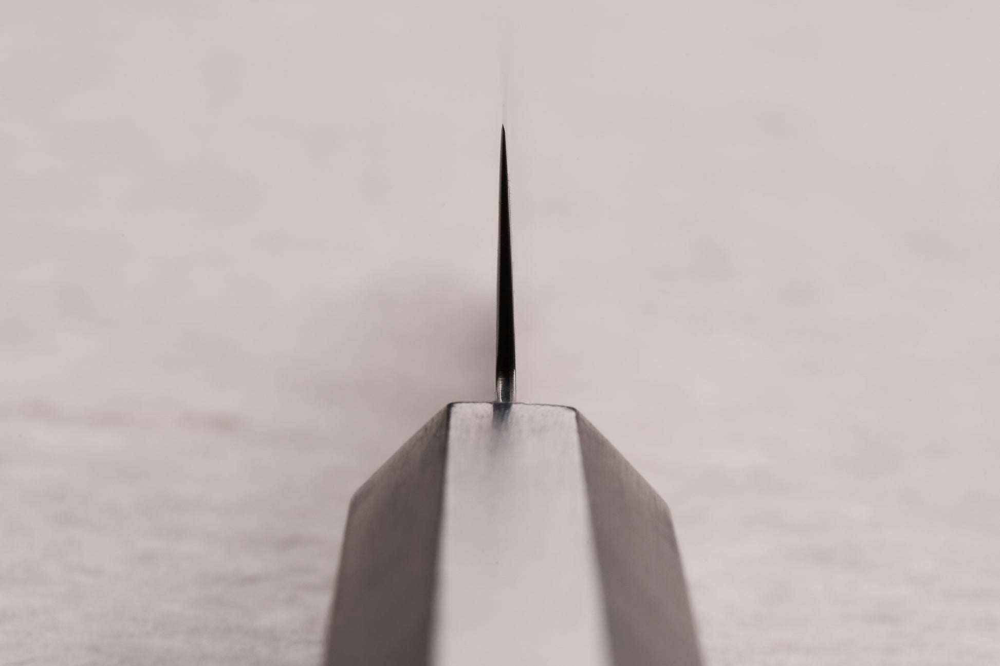 Close-up of the Hatsukokoro Ryuhyo SG2 Kurozome Damascus Petty 150mm knife's blade, showcasing its sharp edge and precision craftsmanship, ideal for delicate kitchen tasks.