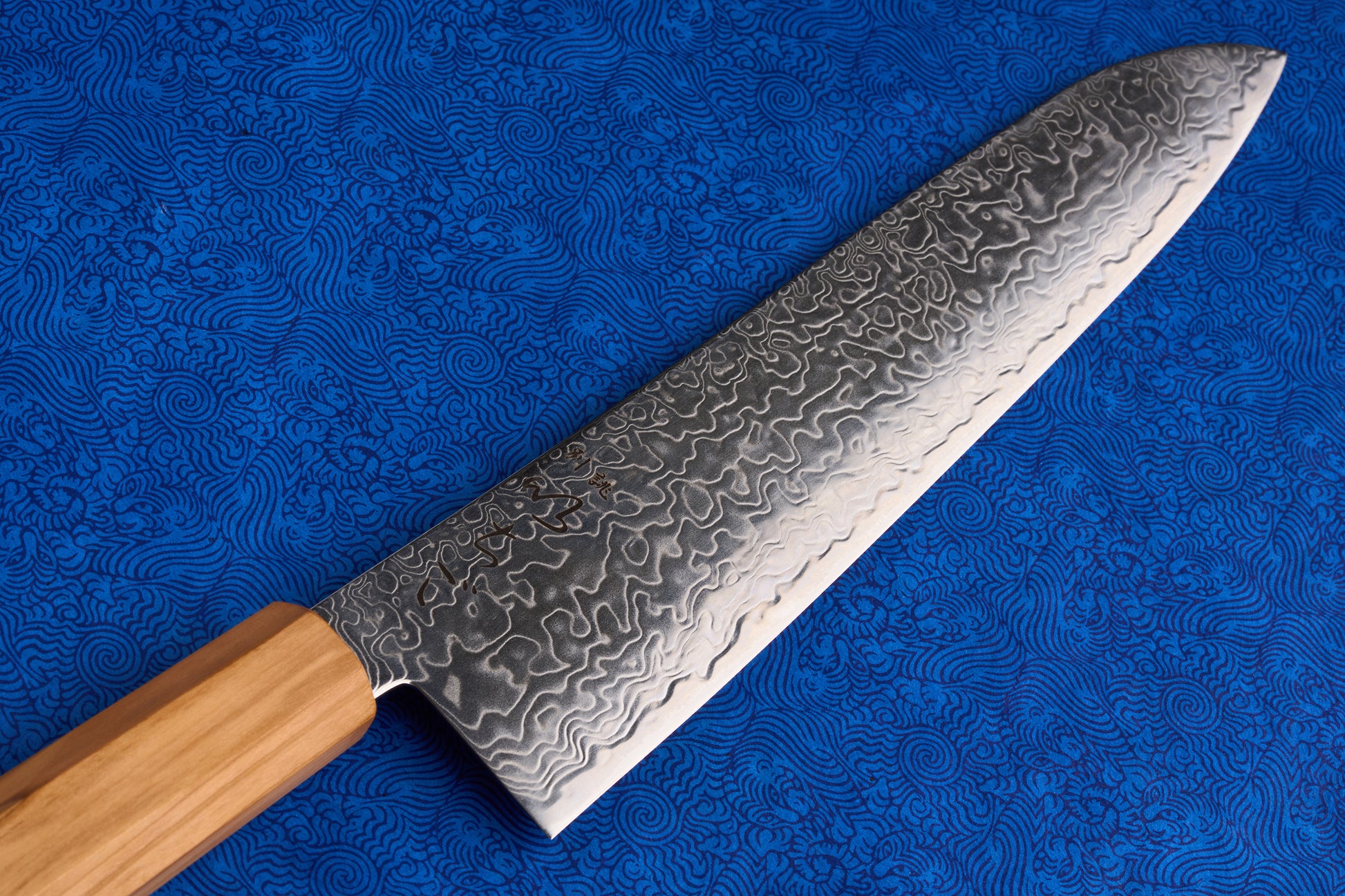 ICHIGO Haku Gyuto 240mm features a Damascus steel blade with a raindrop motif, paired with a light wooden handle, embodying elegance and precision in Japanese knife craftsmanship.