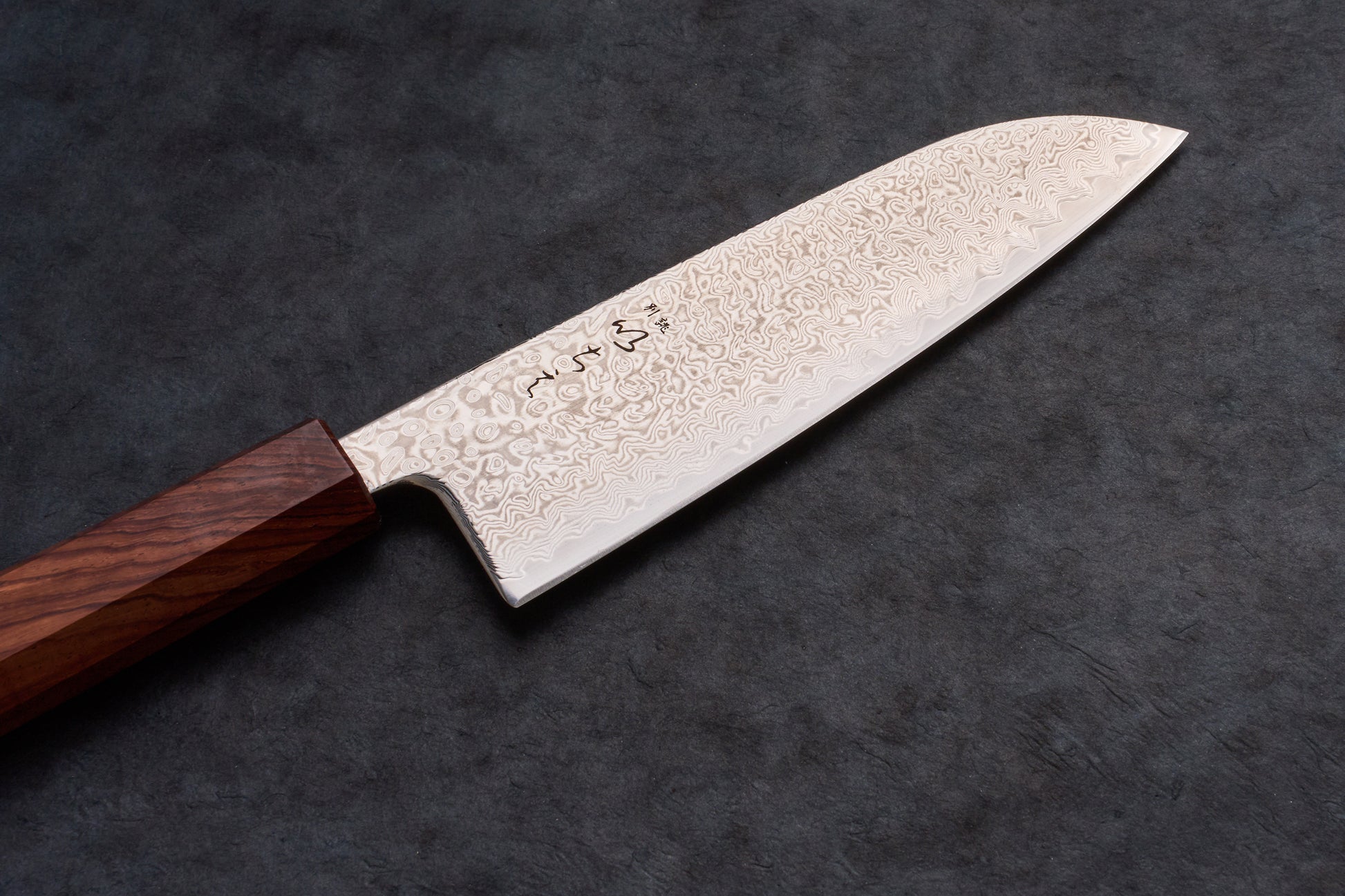 Ichie SRS13 Damascus Santoku 165mm knife, showcasing a swirling Damascus blade pattern and octagonal handle, designed for versatile kitchen tasks like slicing, dicing, and mincing.