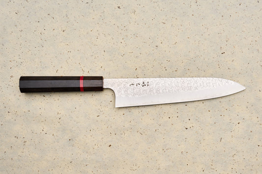ICHIE x Shibata Knives SG2 Tsuchime Gyuto 210mm features a hammered blade, octagonal dark wood handle, and stamped Japanese characters, ideal for versatile culinary use.