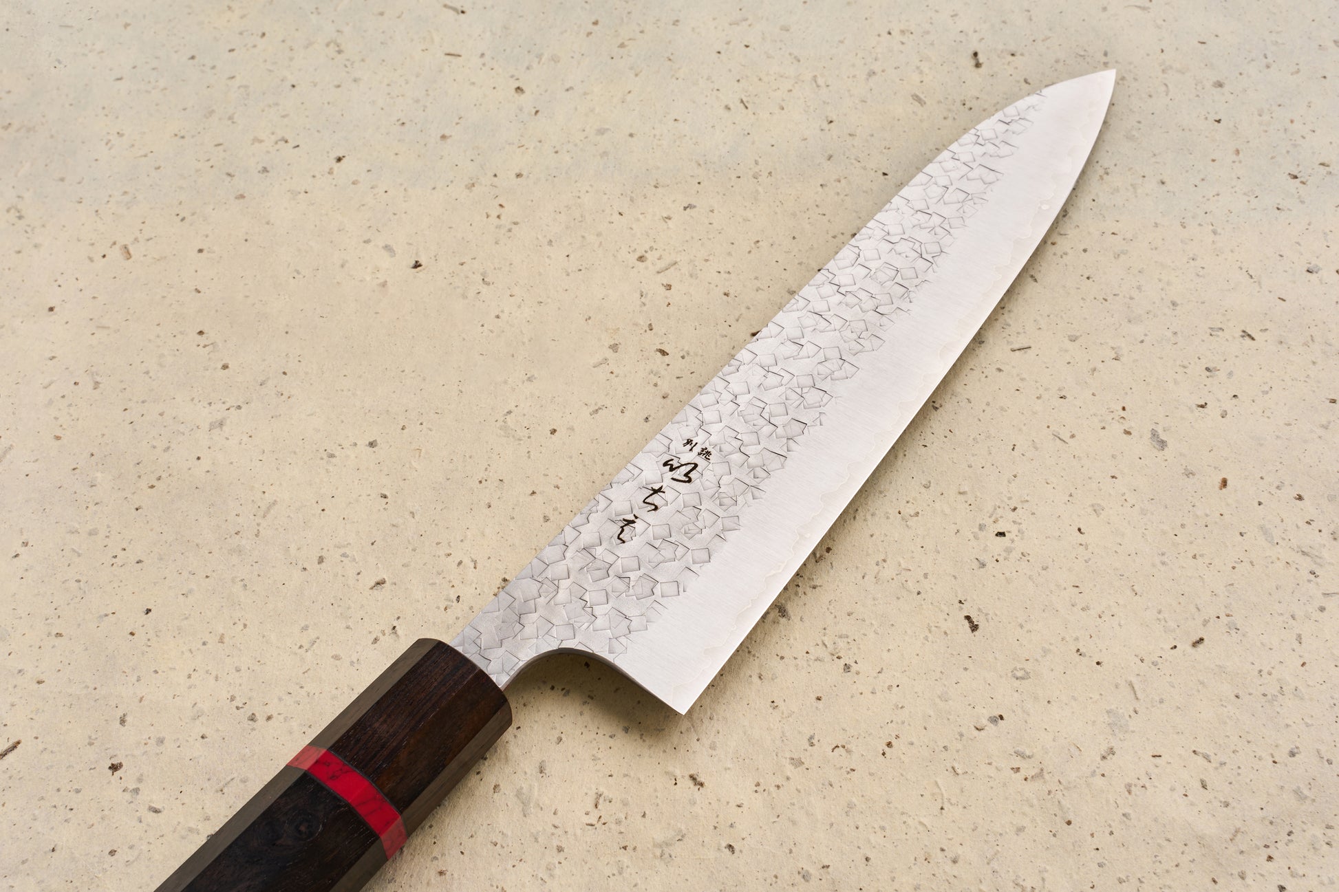 ICHIE x Shibata Knives SG2 Tsuchime Gyuto 210mm, featuring a hammered blade with Damascus patterning and an octagonal wooden handle, showcases Japanese craftsmanship ideal for versatile culinary use.