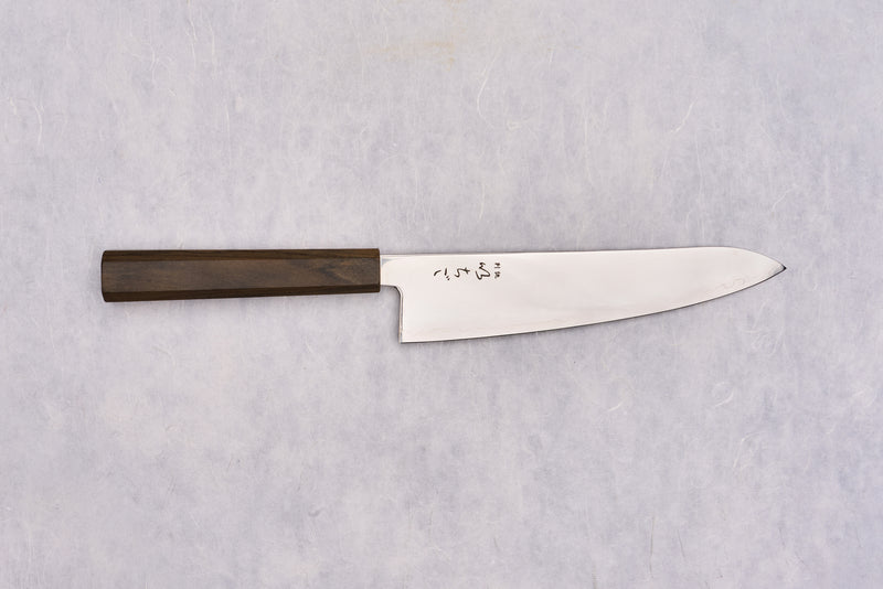 ICHIGO SLD Migaki Gyuto 195mm displayed flat, features a polished steel blade with engraved Japanese characters near the heel and an octagonal wooden handle, embodying Japanese craftsmanship.
