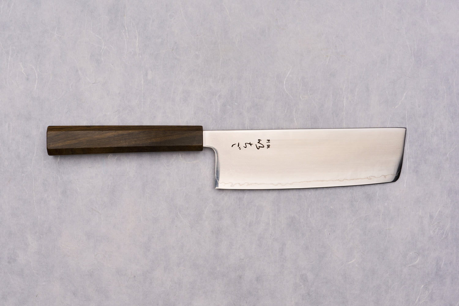 ICHIGO SLD Migaki Nakiri 160mm features a sleek stainless blade with a subtle hamon line and Japanese characters, complemented by a dark wooden octagonal handle, ideal for precise vegetable chopping.
