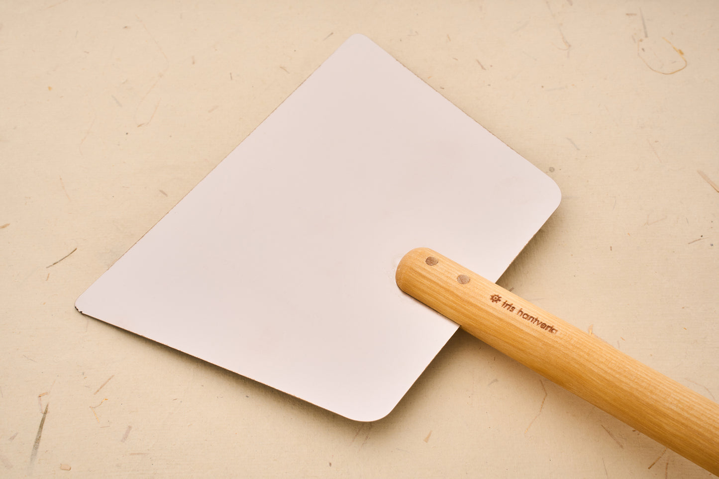 Iris Hantverk Dough Scraper with Handle: A metal tool with a flexible blade and stamped wooden handle, ideal for dividing and gathering dough efficiently.