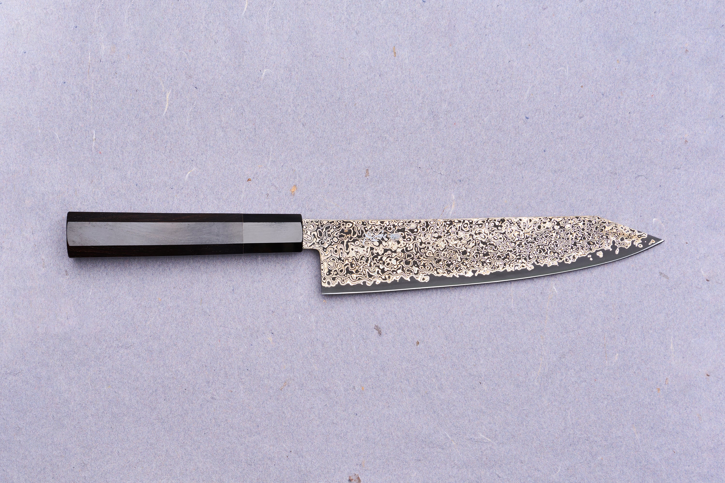Kanjo SG2 Nickel Damascus Kiritsuke Gyuto 210mm: A Japanese chef's knife featuring a patterned Damascus blade and dark octagonal wooden handle, ideal for versatile kitchen tasks.