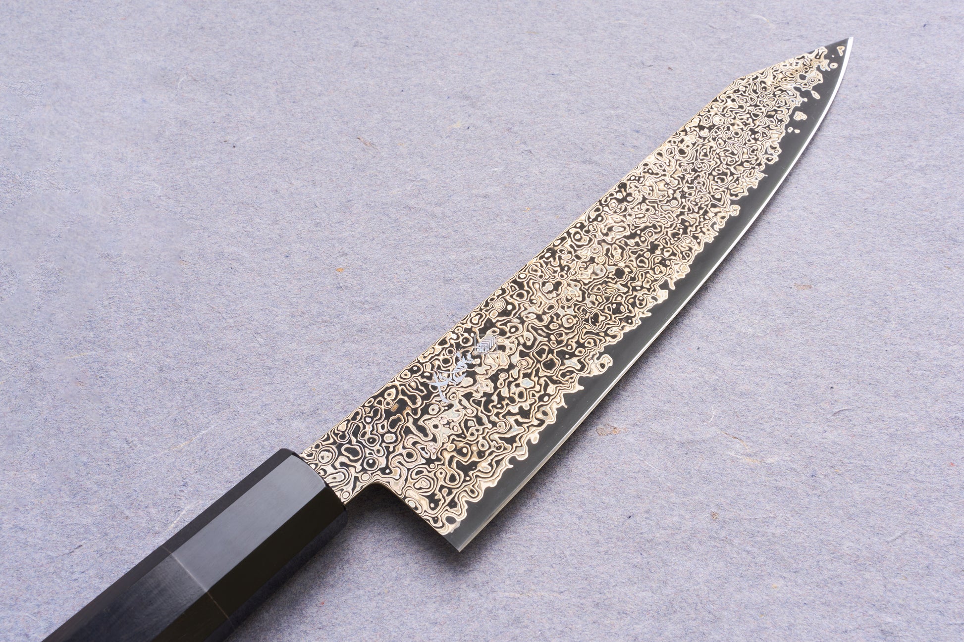 Kanjo SG2 Nickel Damascus Kiritsuke Gyuto 210mm, showcasing its distinctive swirling Damascus-steel blade and octagonal handle, ideal for versatile kitchen use.