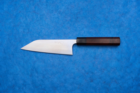 Shibata Koutetsu Chromax Migaki Santoku 165mm knife with a stainless-steel blade and octagonal wooden handle, ideal for slicing, dicing, and mincing, captures Japanese craftsmanship for versatile kitchen use.