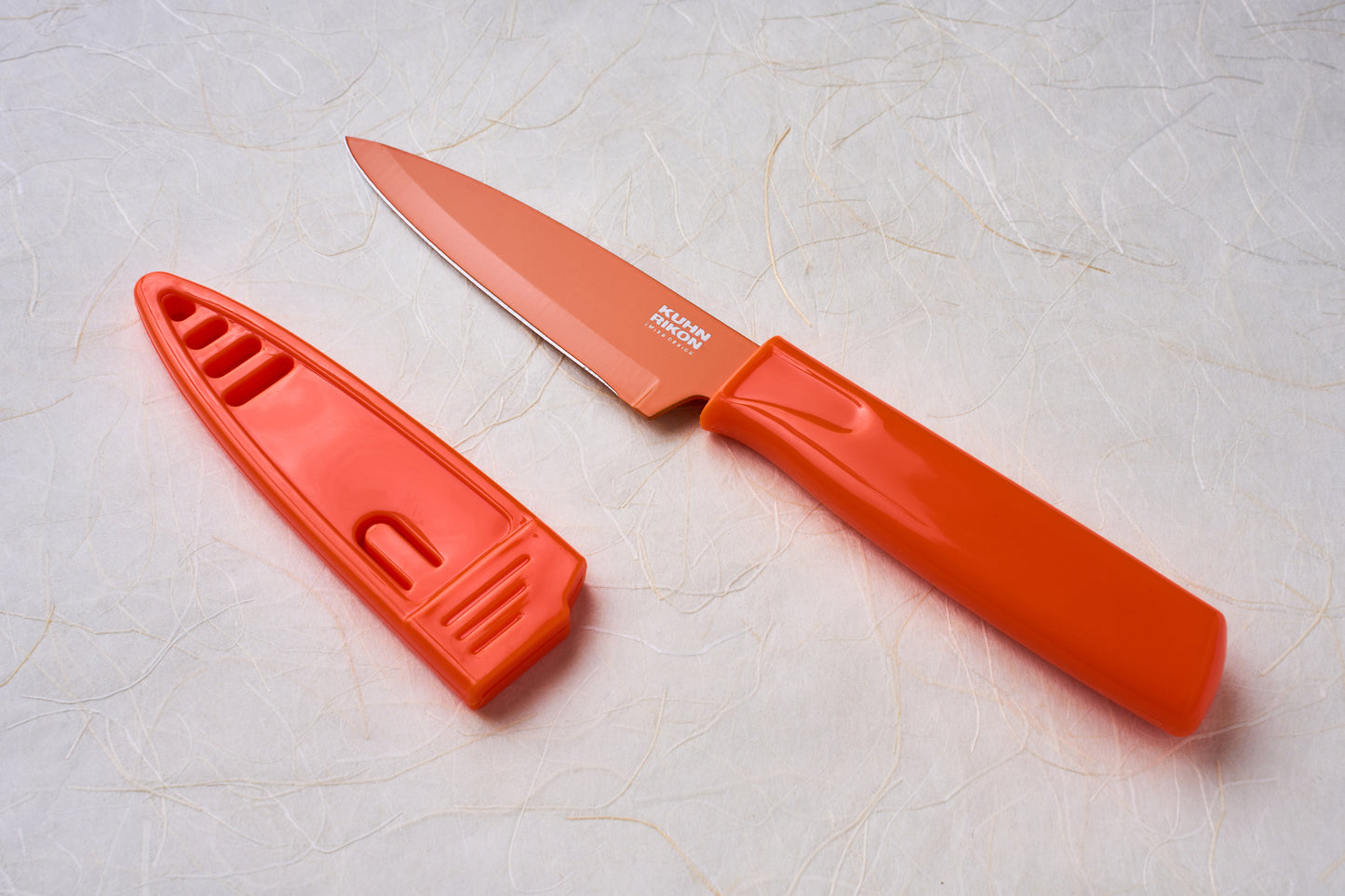Kuhn Paring Knife with orange handle and sheath, featuring a VG10 stainless steel blade, ideal for versatile kitchen or outdoor use.