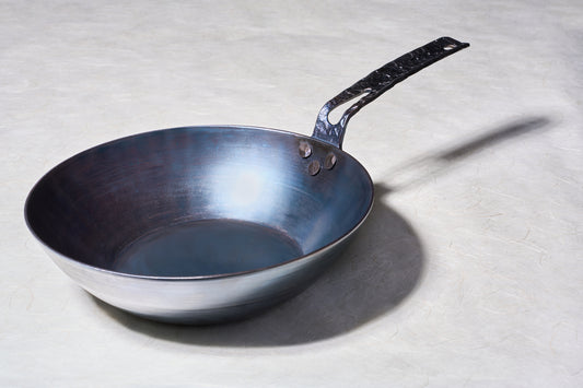 Leechtown Blacksmith Co. Mokwok Carbon Steel Pan Small with a hammered handle, riveted for durability, ideal for various stoves and open fire cooking.