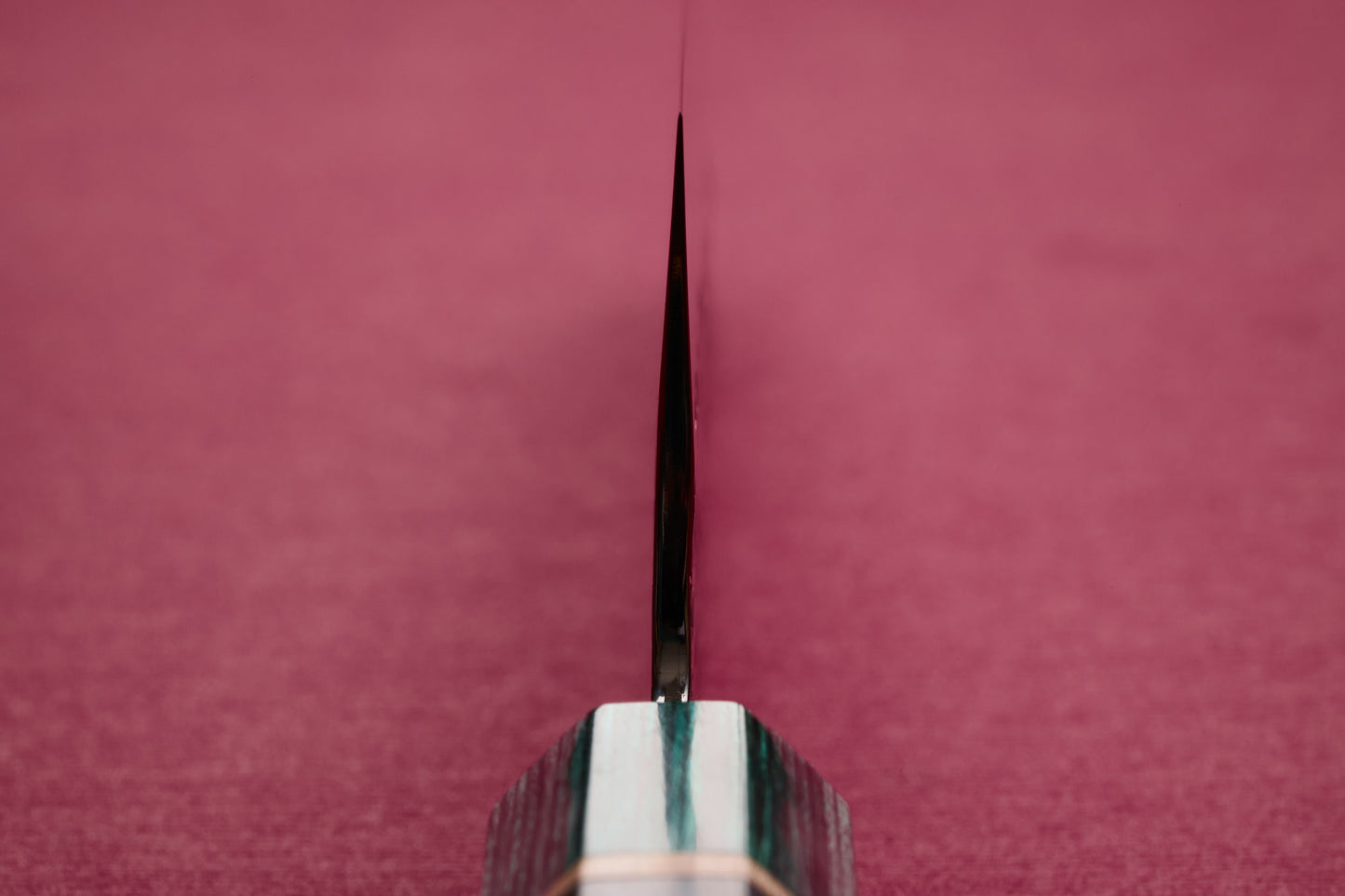 Makoto Kurosaki SPG STRIX Samidorizuki Gyuto 210mm blade edge-on, showcasing its precision steel and patterned handle against a red background, epitomizing Knifewear's commitment to sharp, handcrafted Japanese kitchen knives.