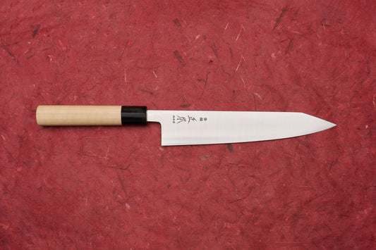 Masamoto KS Hongasumi Kiritsuke Gyuto 210mm knife with a polished, slender blade etched with Japanese characters and a wooden handle, displayed on a textured red background, embodying precision and craftsmanship.