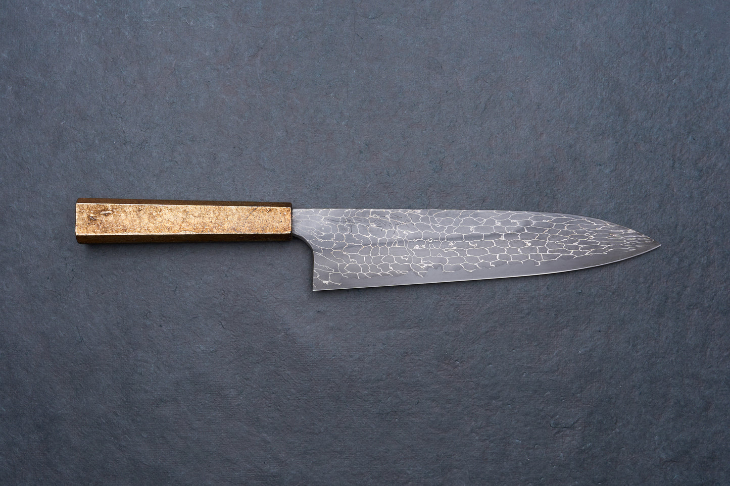 Mazaki Aoichi Beads Black Damascus Gyuto 240mm knife on slate surface, featuring a patterned steel blade and a straight, rectangular wooden handle.