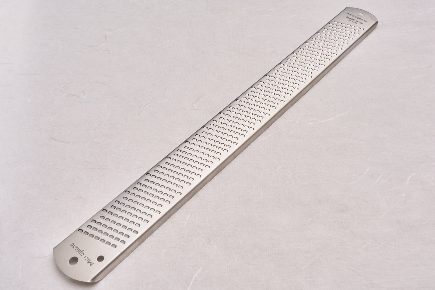 Microplane Zester: A sleek, stainless-steel handheld grater ideal for zesting citrus, grating cheese, or shredding spices, perfect for enhancing dishes in both home and professional kitchens.