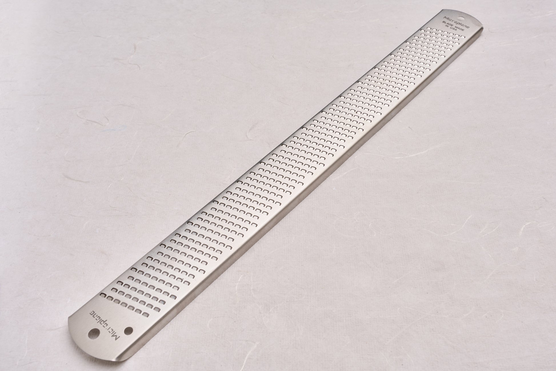 Microplane Zester: A sleek, stainless-steel handheld grater ideal for zesting citrus, grating cheese, or shredding spices, perfect for enhancing dishes in both home and professional kitchens.