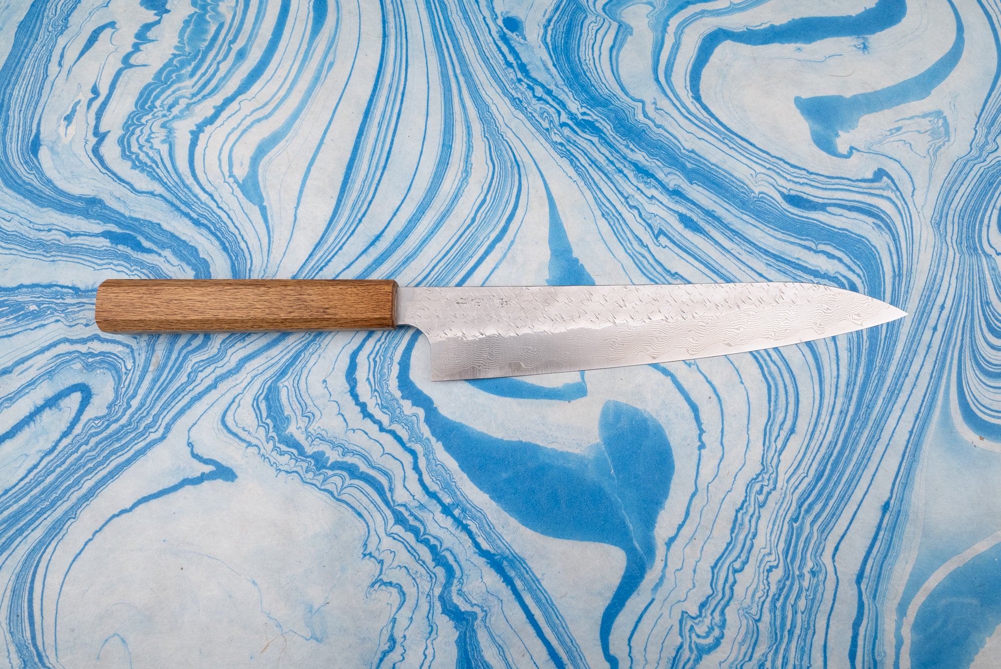 Nigara SPG STRIX Tsuchime Damascus Sujihiki 240mm, a Japanese-style chef's knife, features a narrow, etched Damascus blade and simple wooden handle, ideal for precise slicing tasks.