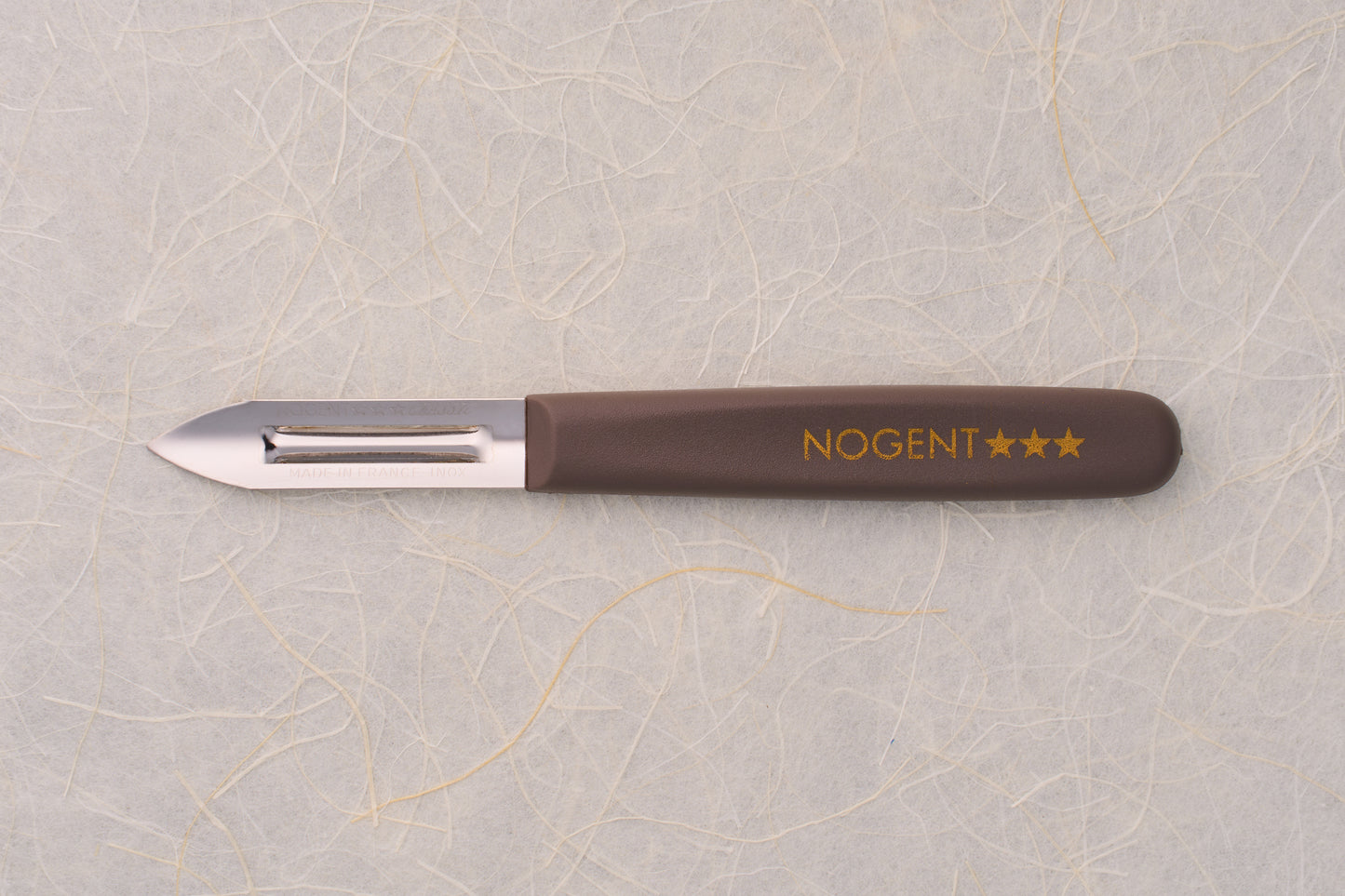 Nogent Double Edge Peeler with stainless-steel blade and brown handle, showcasing craftsmanship from France. Perfect for precise, dual-directional peeling in professional and home kitchens.