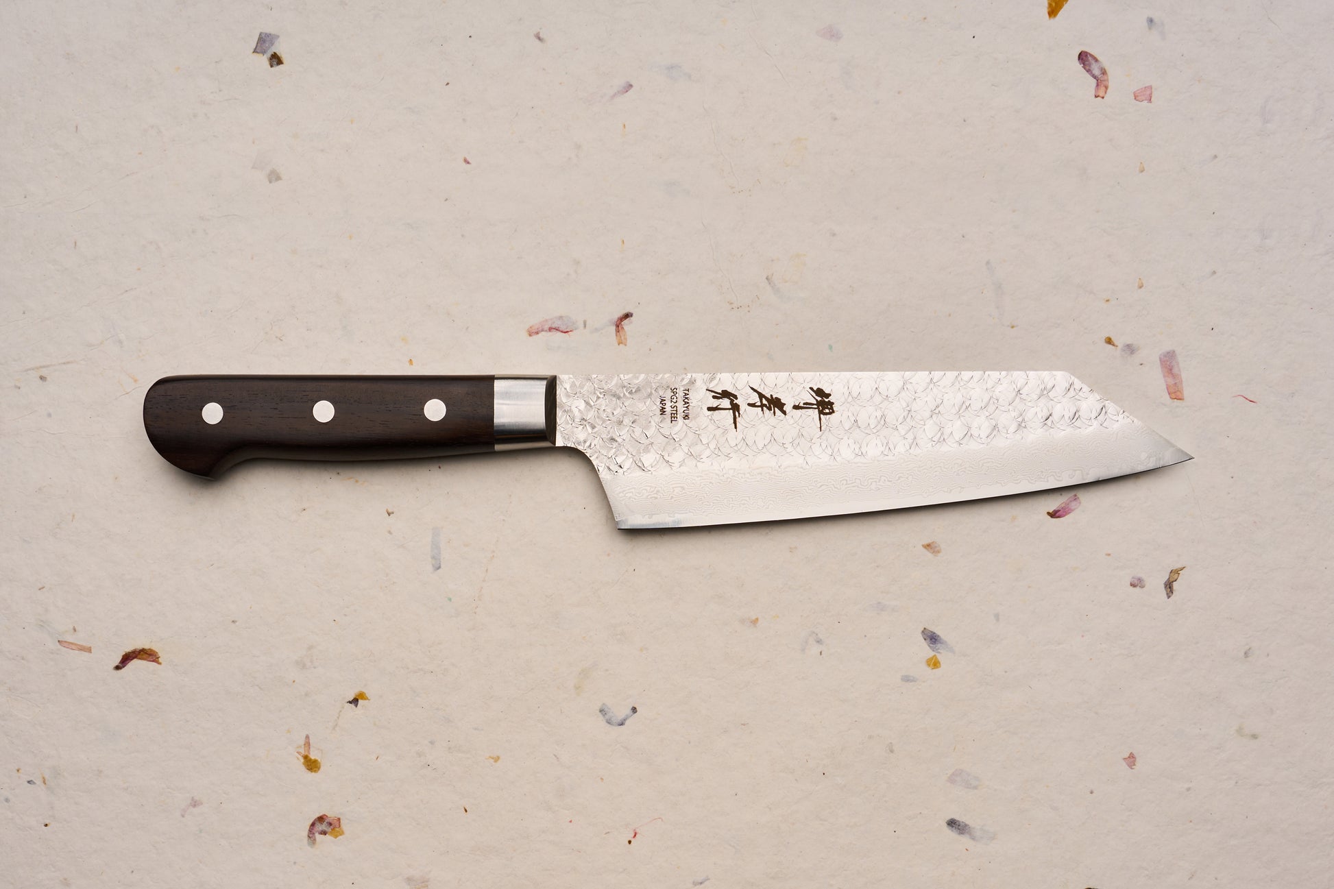 Sakai Takayuki SG2 Tsuchime Damascus Western Kengata Gyuto 190mm features a hammered, Damascus-patterned steel blade with Japanese characters and a dark wooden handle, embodying expert craftsmanship ideal for culinary enthusiasts.