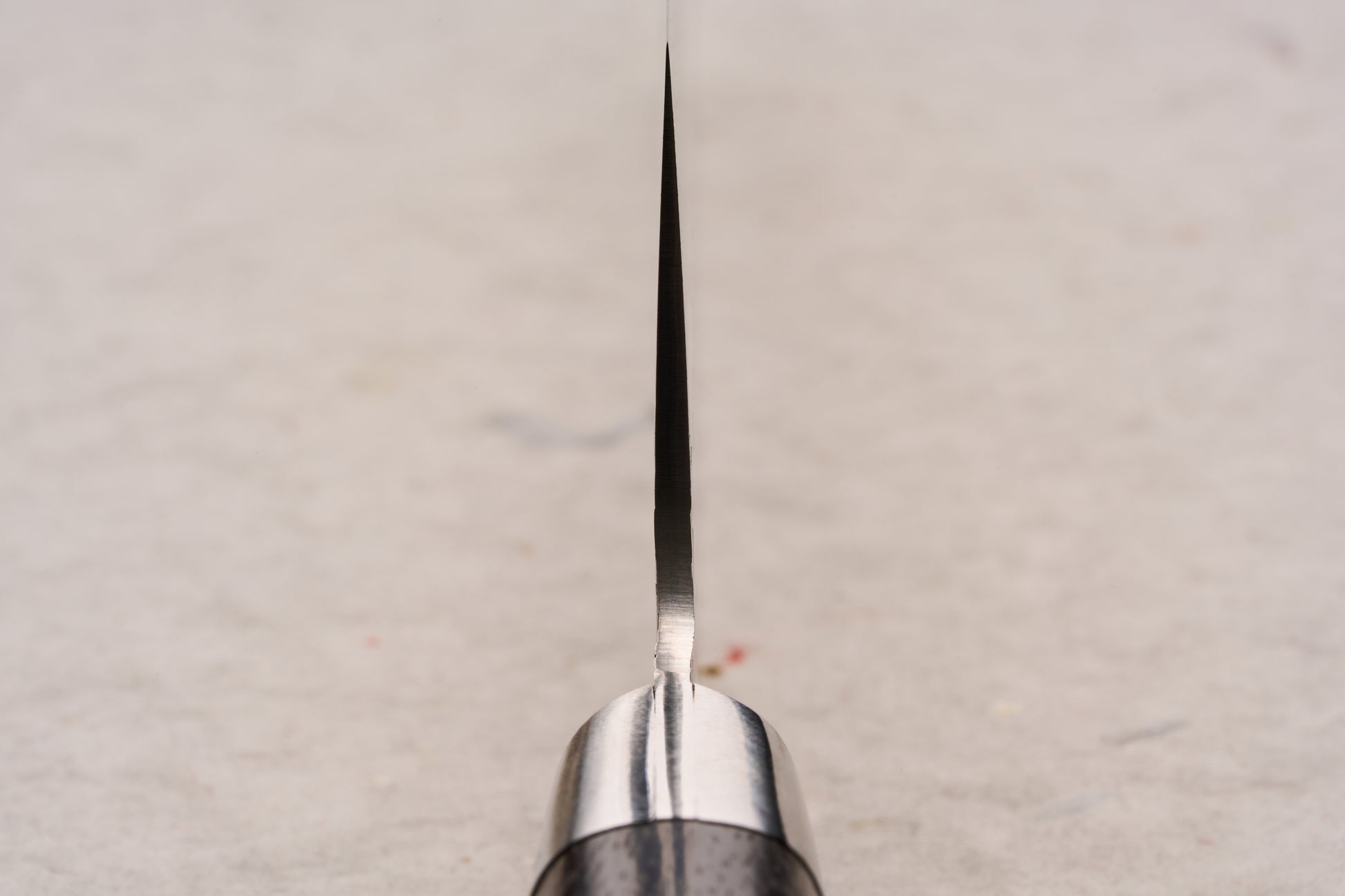 Sakai Takayuki SG2 Tsuchime Damascus Western Kengata Gyuto 190mm viewed edge-on, highlighting its precision-crafted blade rising from the handle, exemplifying Japanese craftsmanship and versatile design for kitchen enthusiasts.