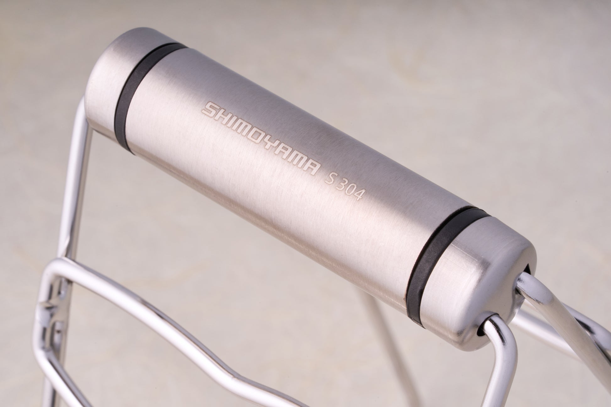 Shimoyama Stainless Steel Dish Clip Lifter, featuring a brushed stainless-steel hinge with fold-out wireframe legs, ideal for versatile use in kitchen or camping settings.