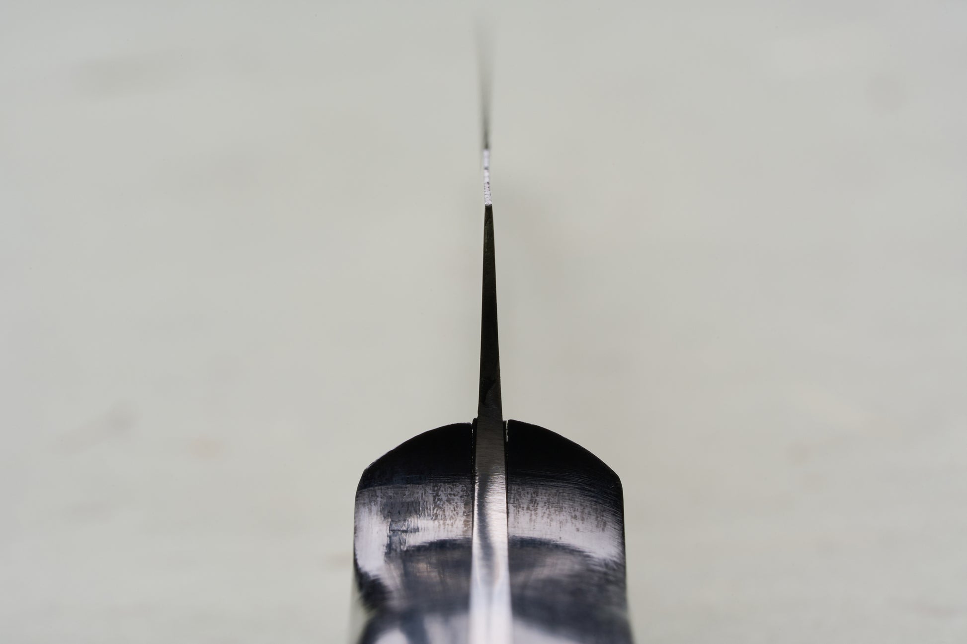 Close-up of TOJIRO Bread Knife 270mm F-687, viewed along the blade's spine, showcasing its scalloped serrations designed for precise bread slicing.