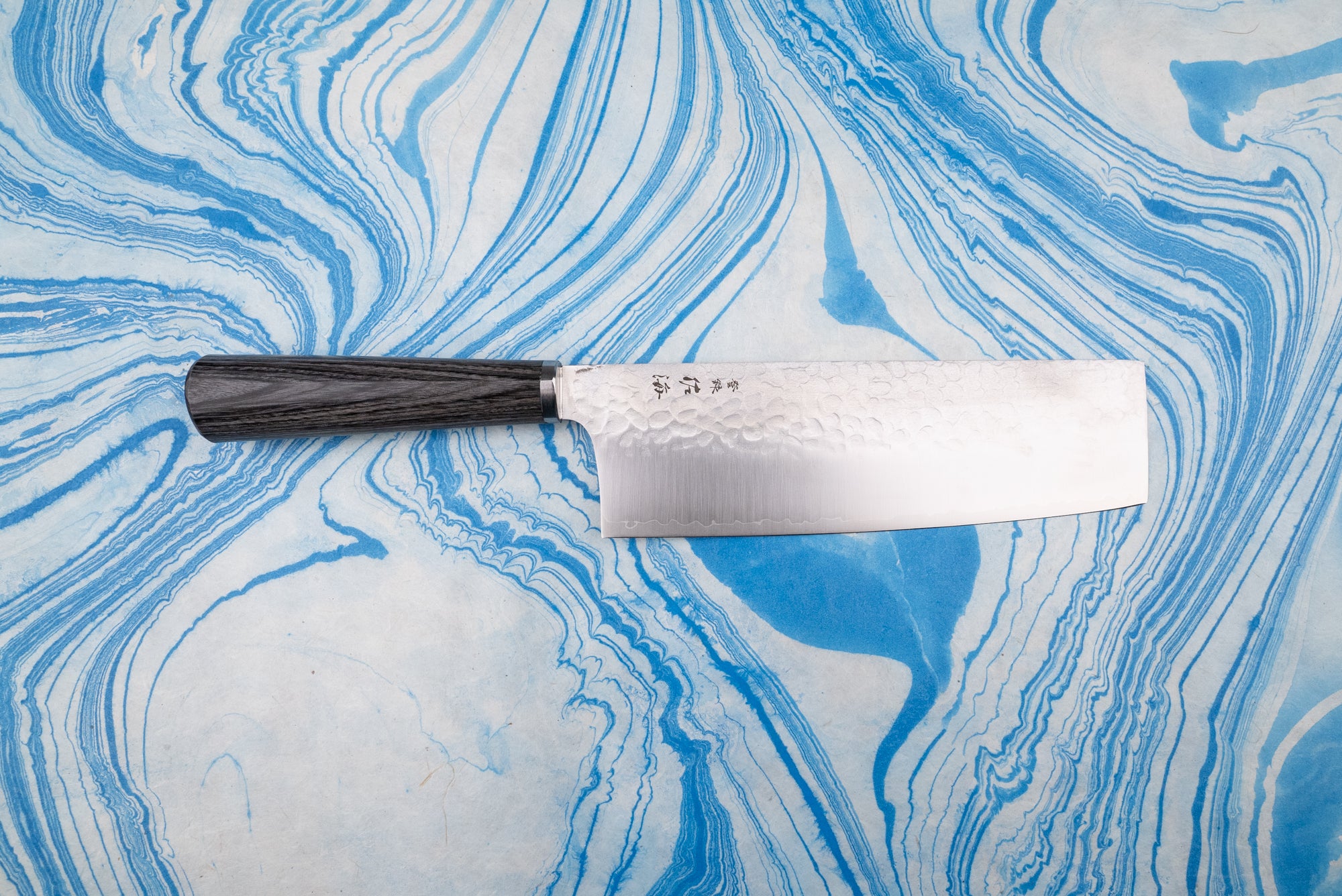 Touroku Sakai Gekka Nakiri 180mm: A Japanese vegetable knife with a rectangular blade featuring a hammered finish and a straight dark wooden handle, ideal for precise, push/pull vegetable chopping.