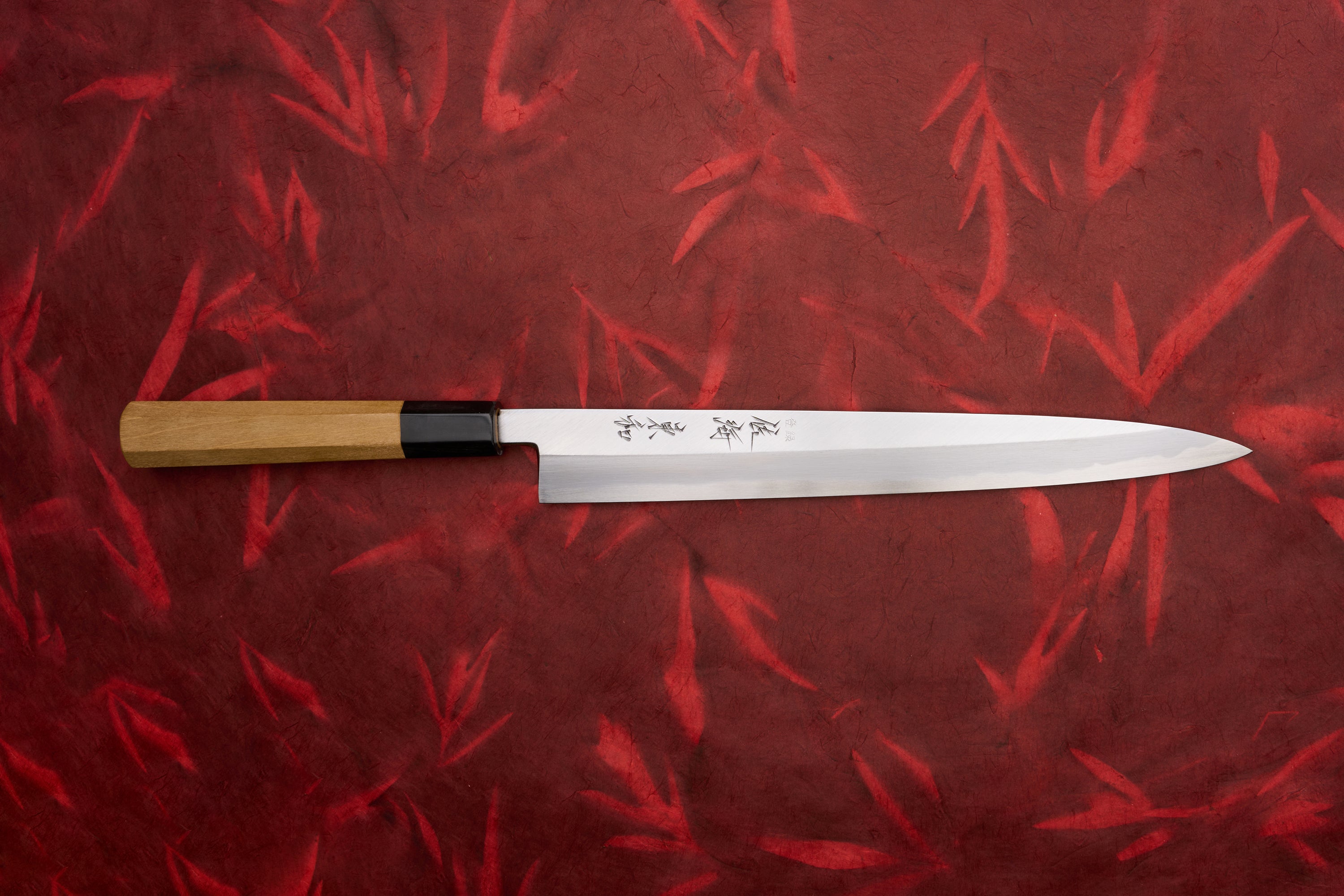 Touroku Sakai Tohwa Shirogami Yanagiba 270mm knife features a slender, single-bevel stainless-steel blade with Japanese engravings, black ferrule, and octagonal wooden handle, perfect for slicing sashimi and carving meats.