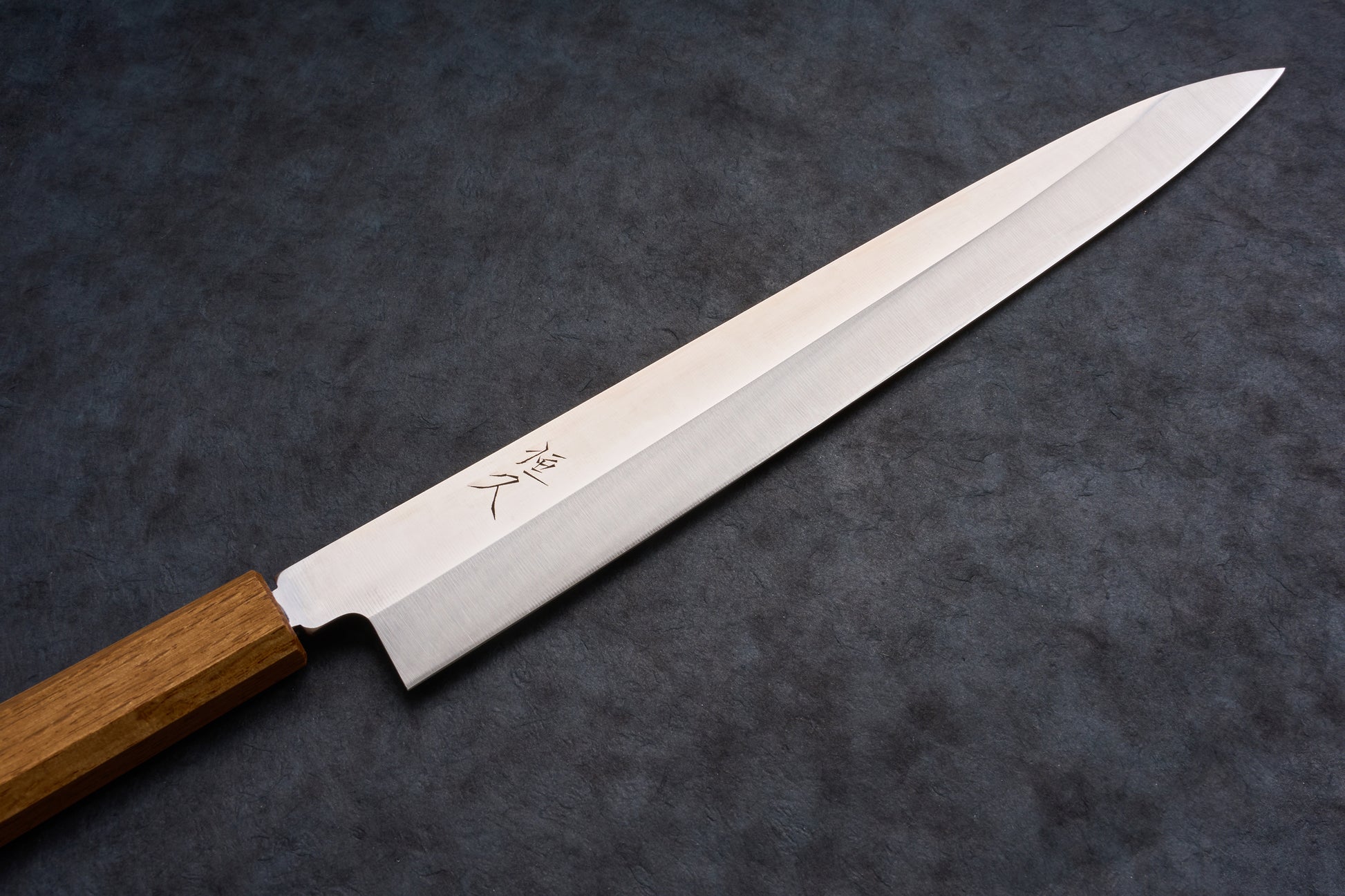 Tsunehisa AUS8 Sanjukyu 参拾玖 Migaki Yanagiba 300mm T-03920 with etched blade and octagonal handle, perfect for slicing sashimi, on a slate surface.