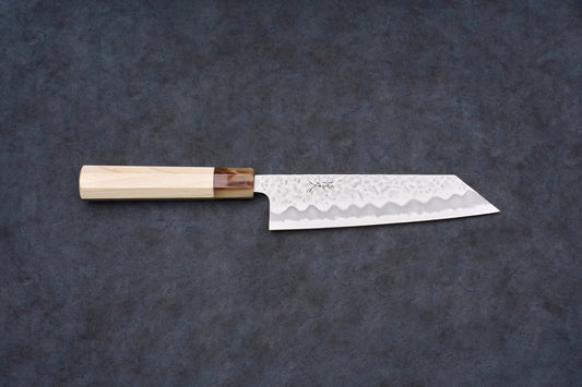 Tsunehisa Shiroichi Stainless Nijuhachi 廿捌 Tsuchime Bunka 165mm knife, featuring a hammered blade and octagonal wood handle, on a dark surface.