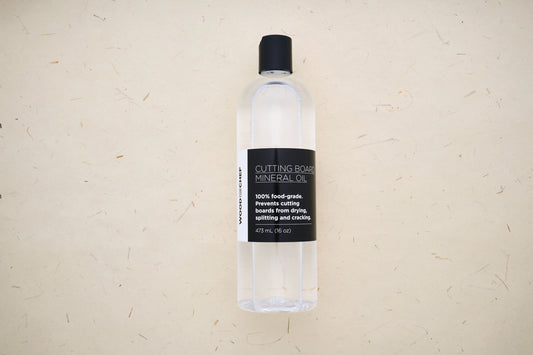 WoodforChef Cutting Board Mineral Oil in a 473 mL clear bottle with black label, ideal for hydrating and protecting cutting boards from drying and cracking.