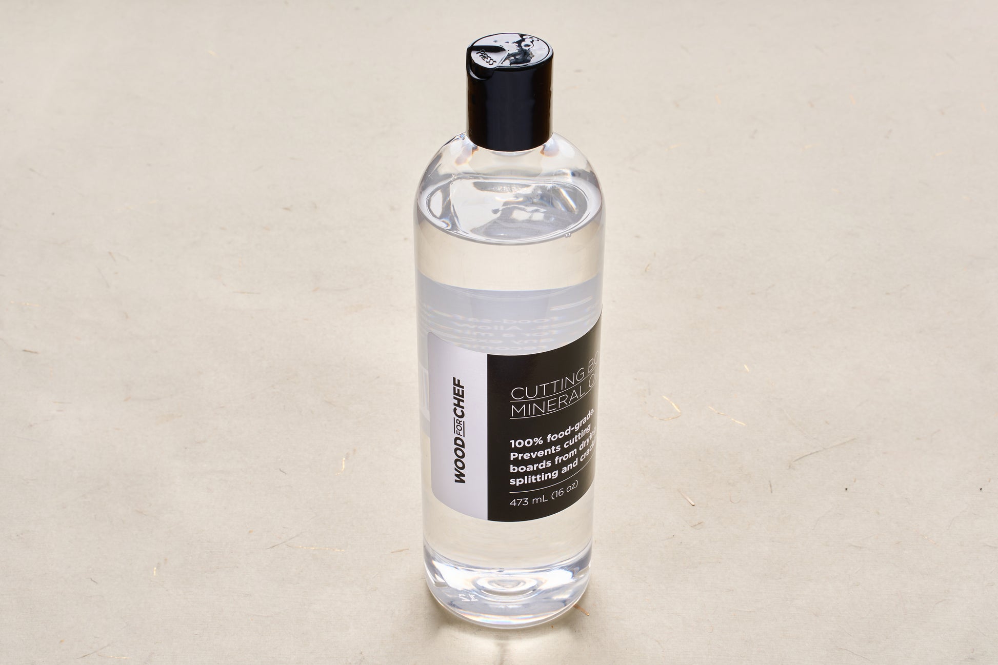 WoodforChef Cutting Board Mineral Oil in a clear bottle with a black cap, ideal for conditioning wooden boards. Food-grade, 473 mL.