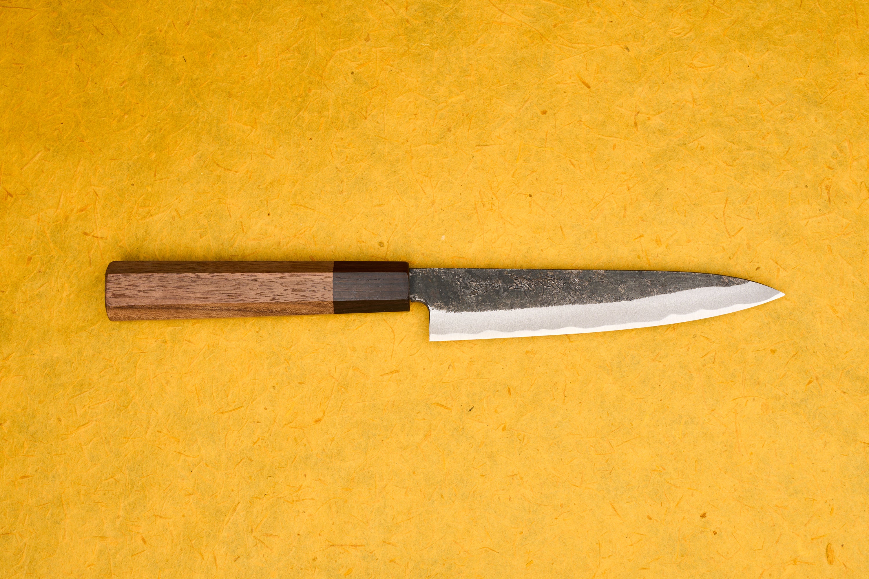 Touroku Sakai Yoshikazu Shirogami Kurouchi Petty 150mm knife, featuring a slender, razor-sharp blade with a temper line and an octagonal wooden handle, ideal for precise cutting tasks.