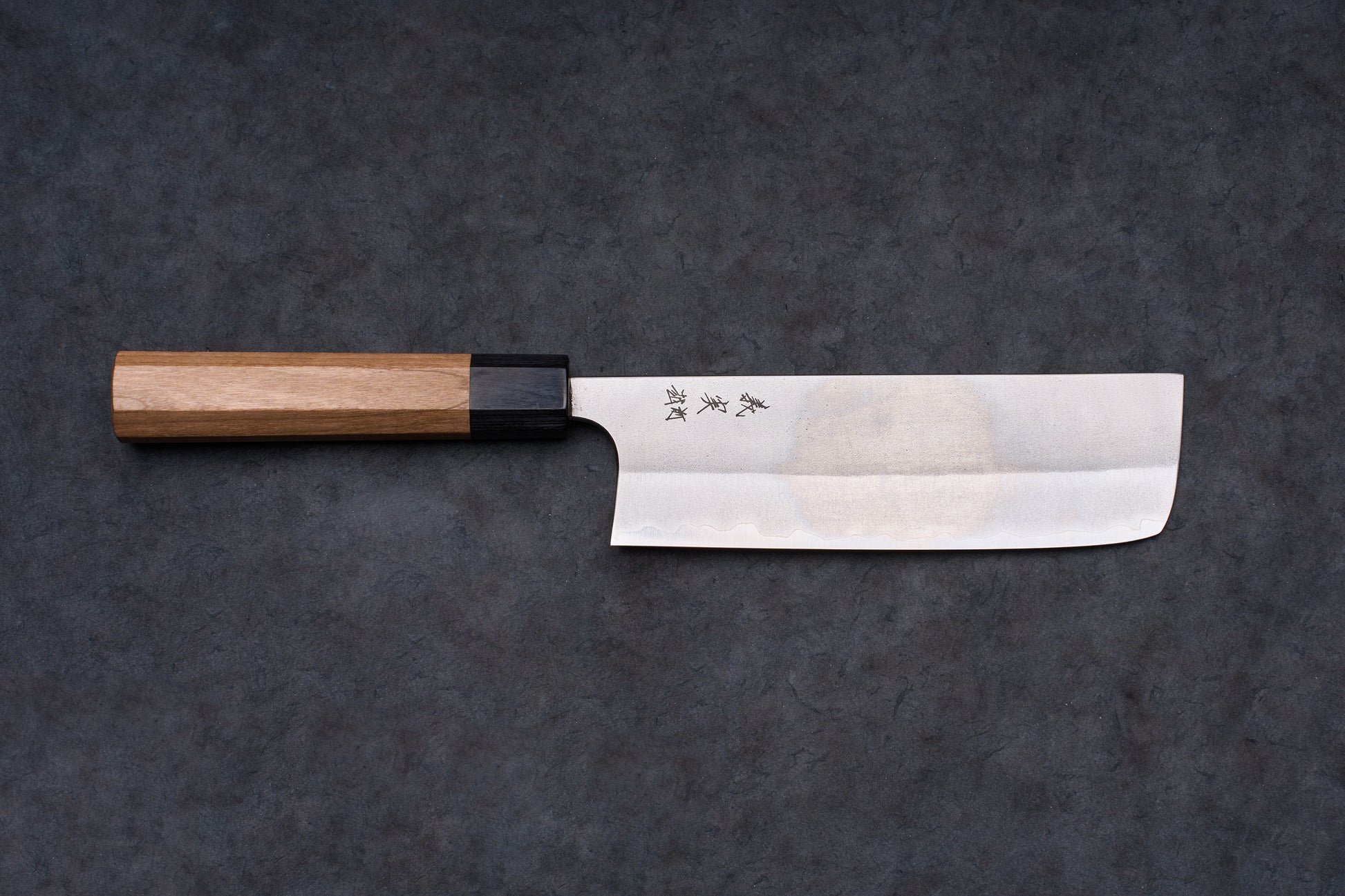 Yoshimi Kato AS/S Nashiji Nakiri 165mm knife with a stainless-steel blade, kanji engraving, and octagonal wooden handle on a dark surface.